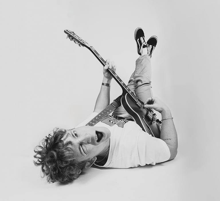 portrait of a man lying with a guitar and a guitar