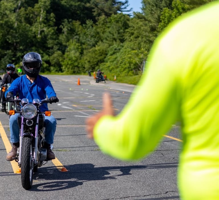 Mokinys vairuoja motociklą instruktoriaus prieziūroje aikštelėje