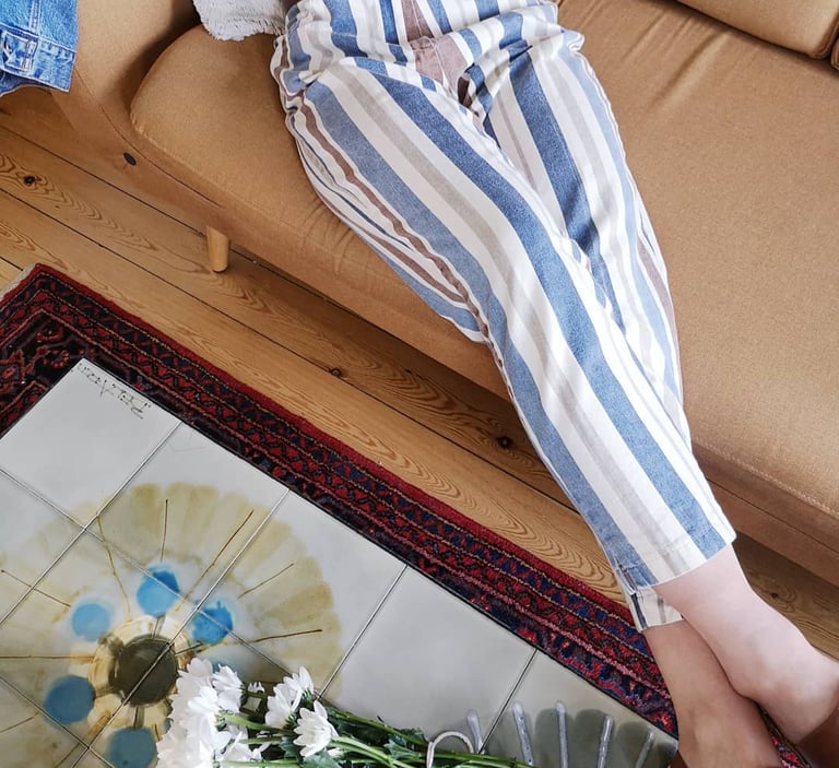 a person sitting on a couch with flowers pantalon vintage 