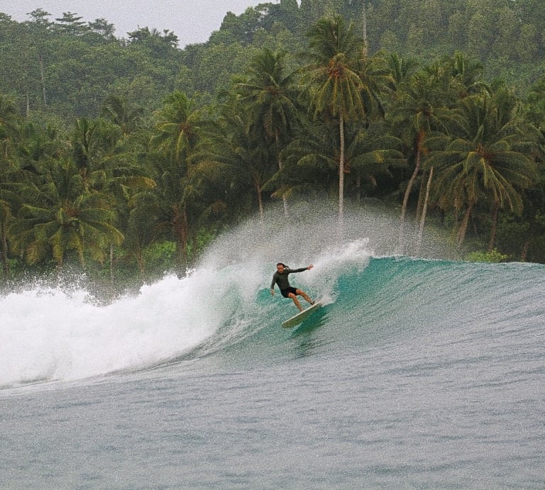 a surfer is riding a wave in the ocean of mentawai