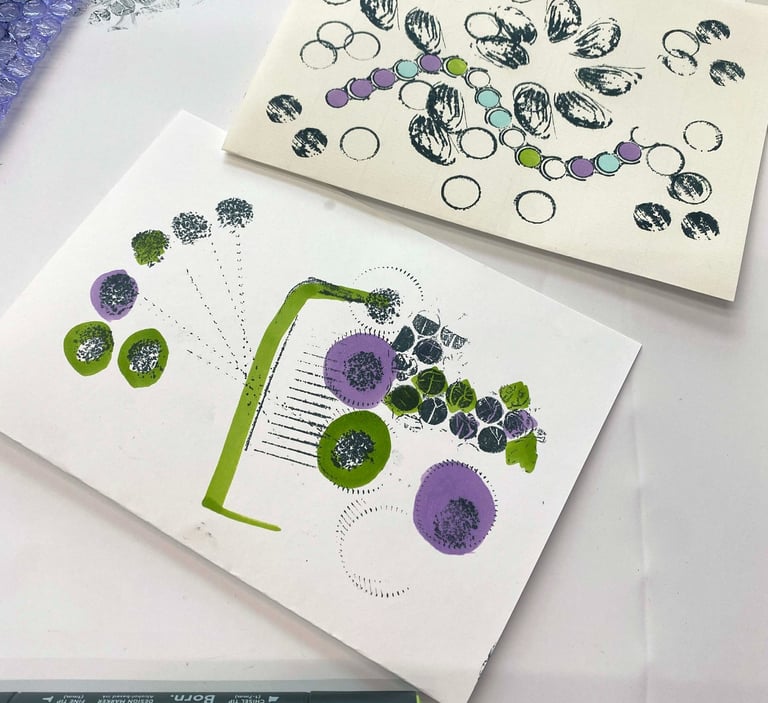 Paper zines with handmade stamps and ink outlines of shapes such as buttons and nut shells.
