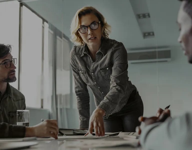 Equipe profissional colaborando durante uma reunião em uma sala de reuniões de escritório.