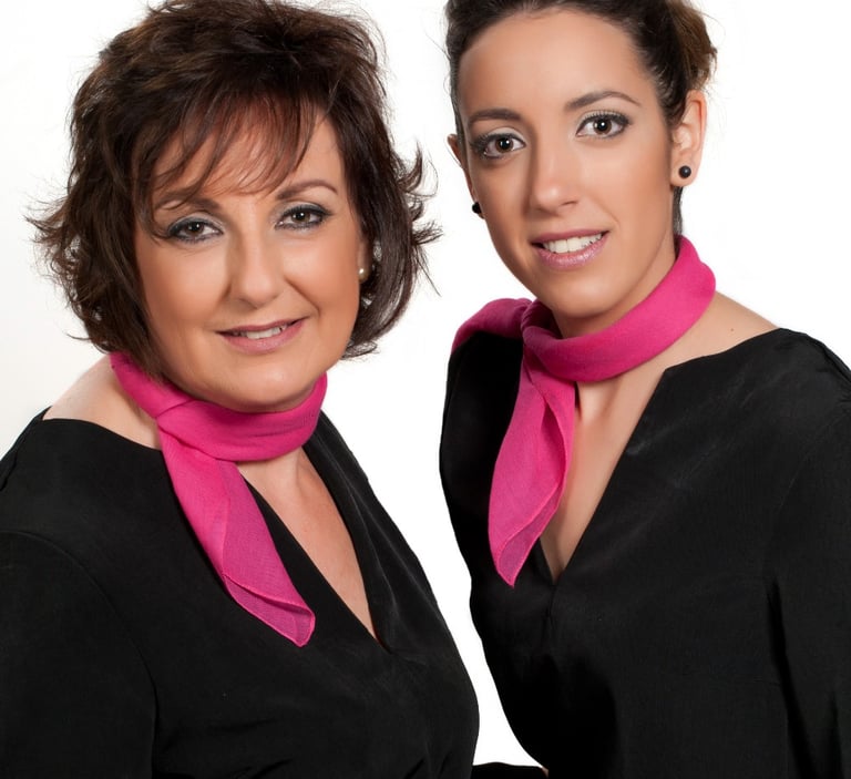two women in black dresses and pink scarf