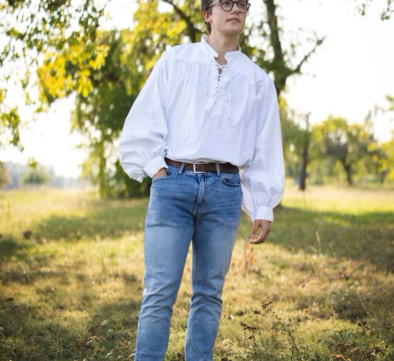 Man in blue jeans wearing an eighteenth century style mens shirt.