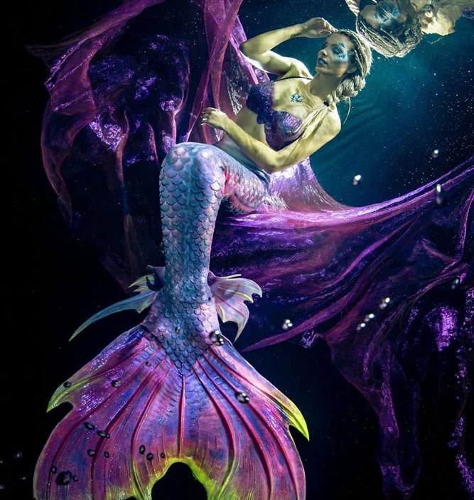 A dark purple and neon green tail by Mermaid Kat with multi colored ankle fins.