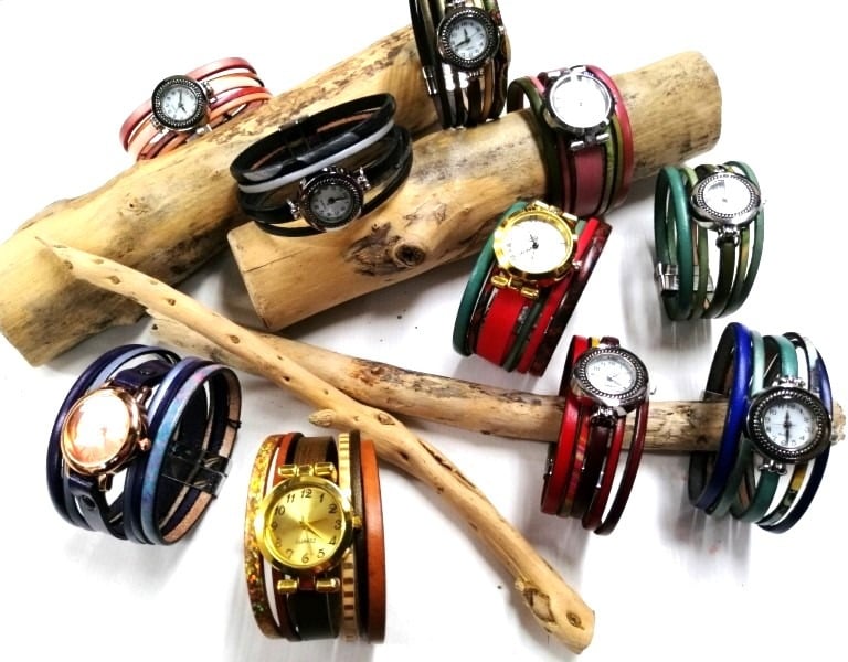 a bunch of bracelets and watches on a stick