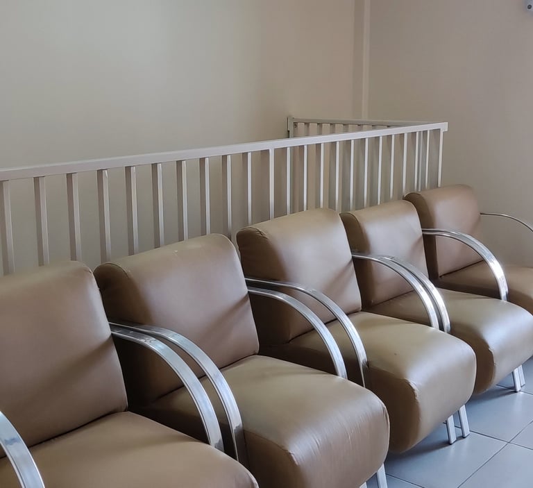 Área de espera com cadeiras estofadas.