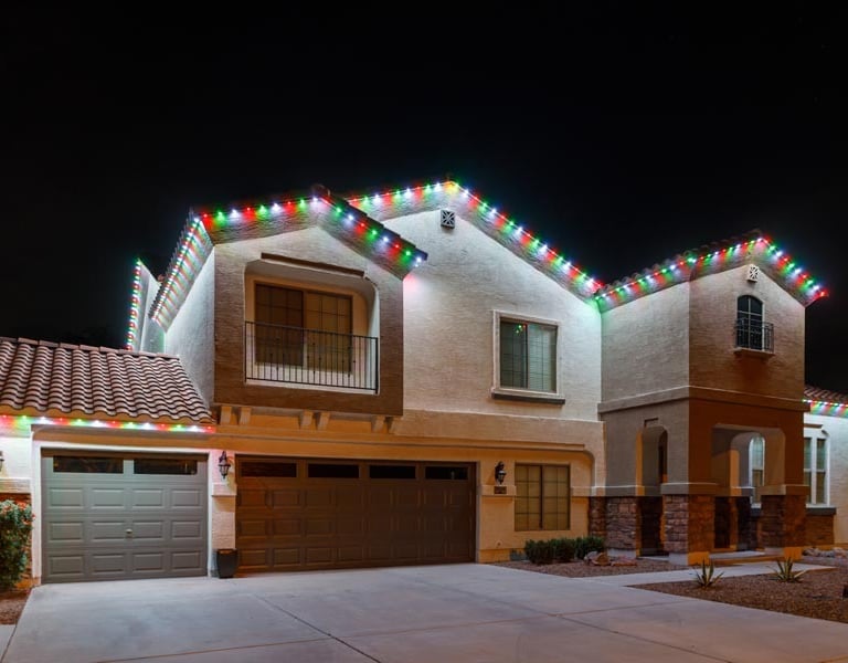 Beautiful lit home exterior with permanent outdoor holiday lighting for festive seasons.