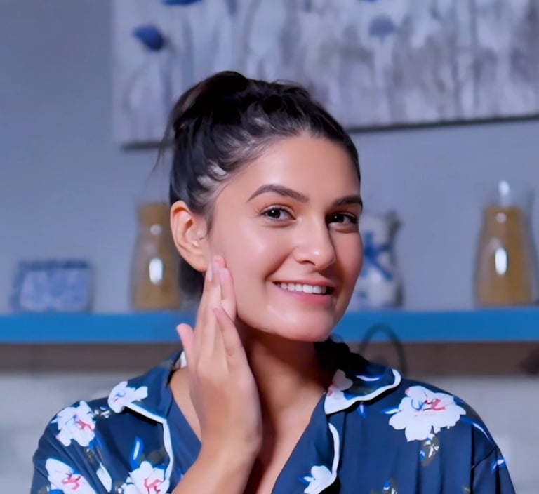 a woman touching her face in a blue shirt 