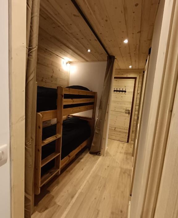 Mountain sleeping area with bunk beds and wooden interiors inside a practical Val Thorens ski-in ski-out apartment.