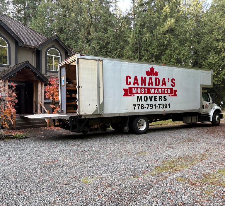 Canada’s Most Wanted Movers truck parked at a forest-side home in the Lower Mainland during a residential move.