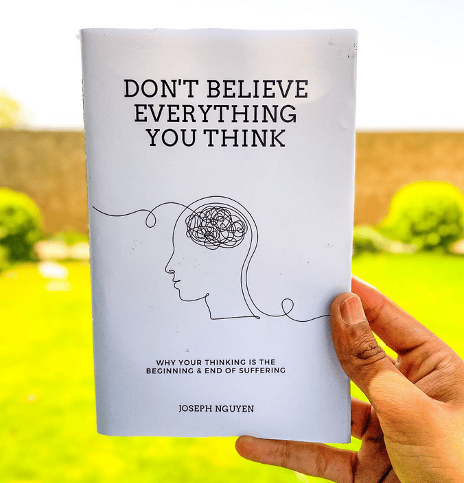 a person holding a book with a drawing of a brain names don't believe everything you think