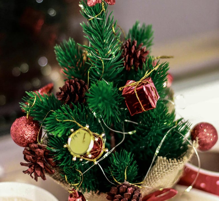 Tabletop mini Christmas trees with burlap bases and fairy lights on a shelf for simple holiday décor