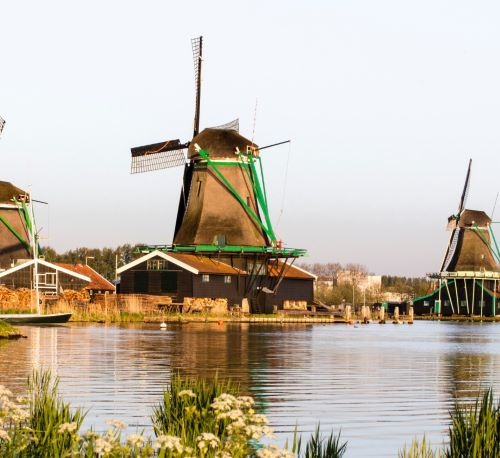 Traditional Dutch windmills along the river at Zaanse Schans in the Netherlands.