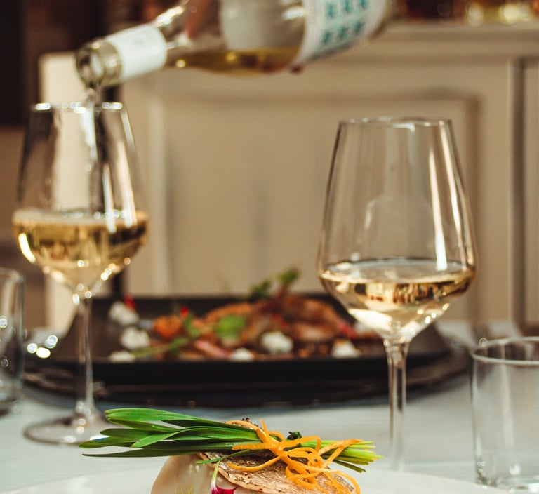 Filetto di pesce bianco su letto di verdure, con erba cipollina e fiori, servito con vino bianco