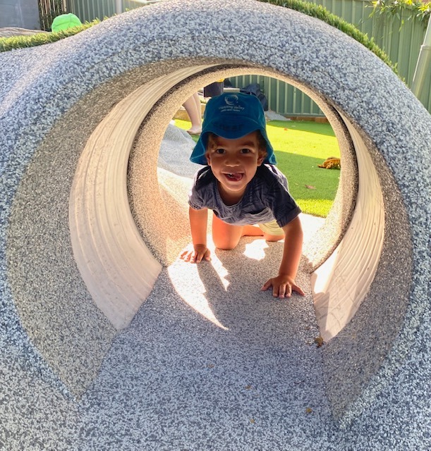 child playing in tunnel