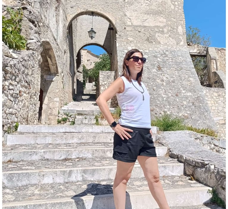 a woman standing on steps leading up to a stone building