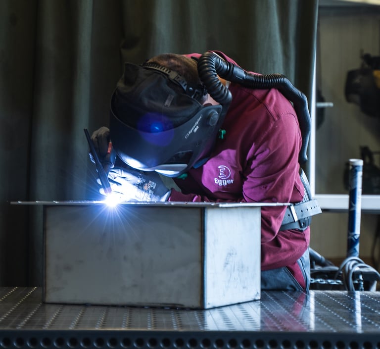 Produktionsmitarbeiter, der ein Gehäuse schweißt