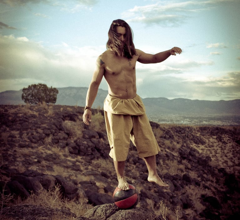 Joshua Fabia posing for a picture on a medicine ball in the Petroglyphs of New Mexico