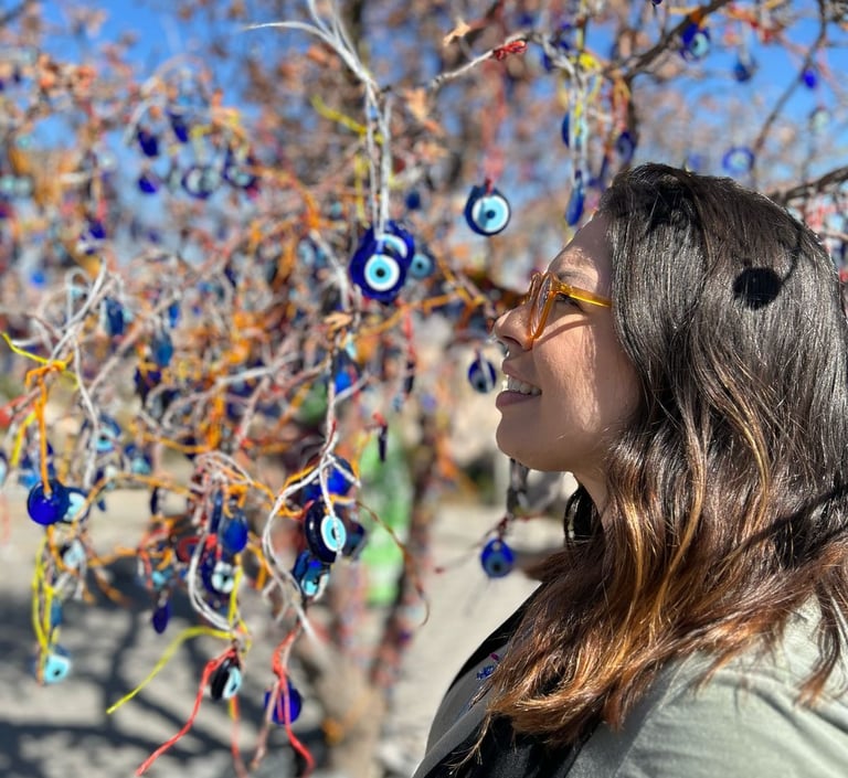 Uma mulher de perfil ao lado de uma árvore com enfeites na Turquia