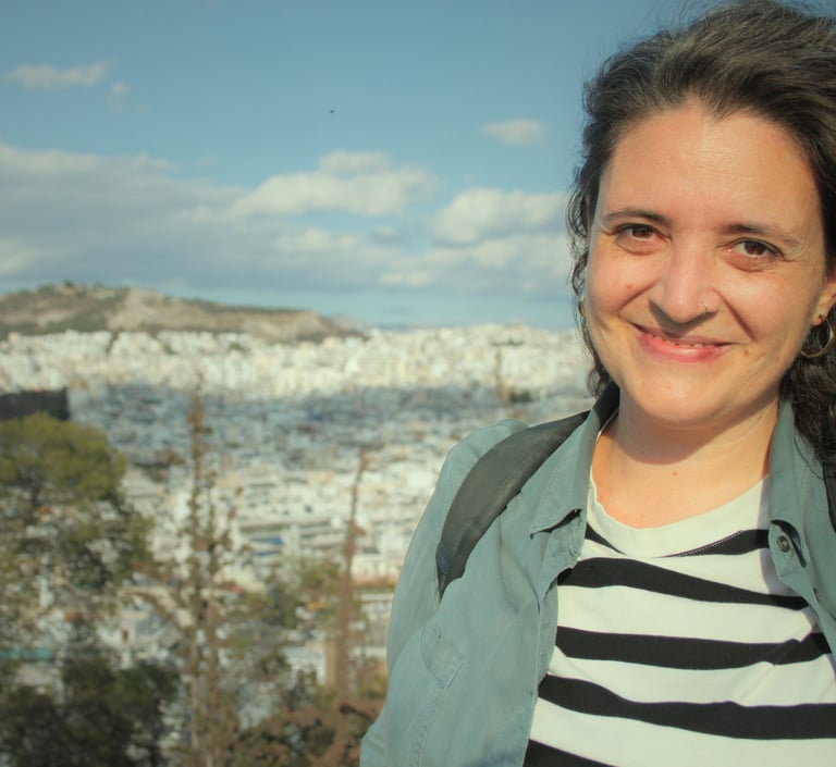 Ângela smiling with a city view behind her