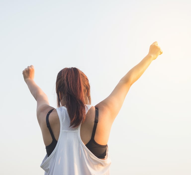 Eine Frau die ihre Arme in die Luft streckt