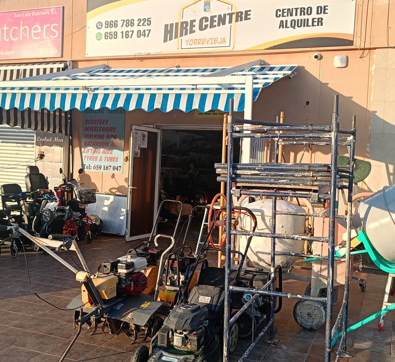 Torrevieja hire centre storefront with rental equipment like wheelchairs, lawn mowers, and a cement mixer.
