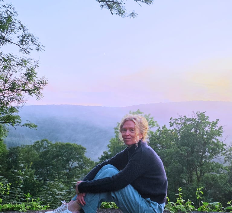 Tanja Holvoet in een rustige natuuromgeving bij zonsondergang.