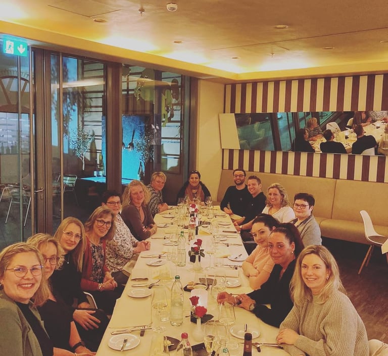 a group of people sitting at a long table