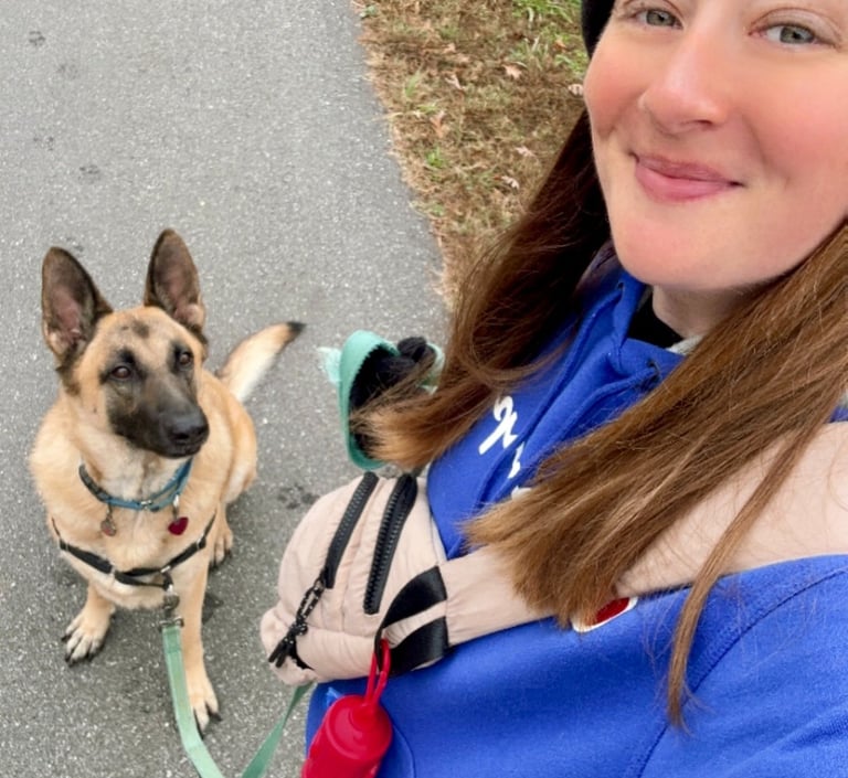 a woman in a blue jacket and hat with a dog on a leash