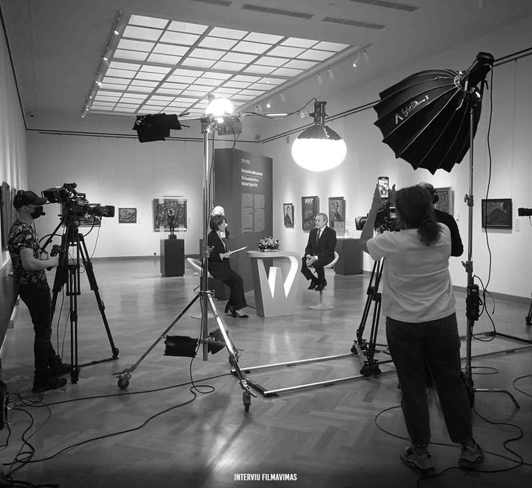 Profesionali filmavimo komanda, naudodama vaizdo kameras ir studijinį apšvietimą, filmuoja interviu.
