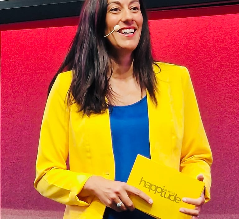 Aurelie Litynski speaking on stage about positive workplace culture