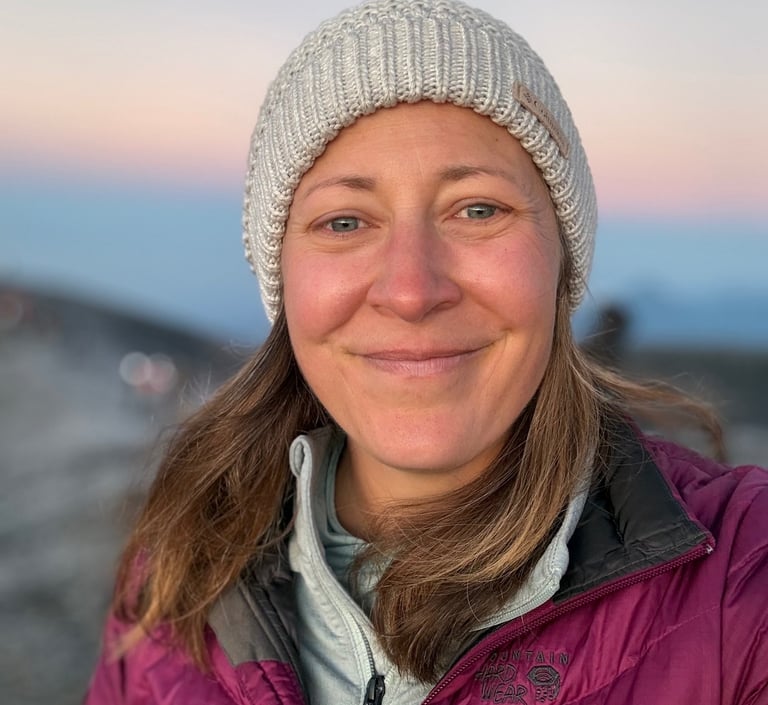 a woman in a purple jacket and a white hat