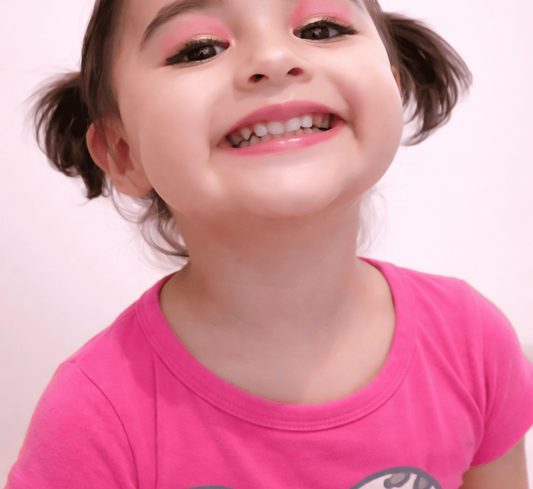 Niña sonriente con maquillaje delicado que representa la belleza auténtica de SAM.