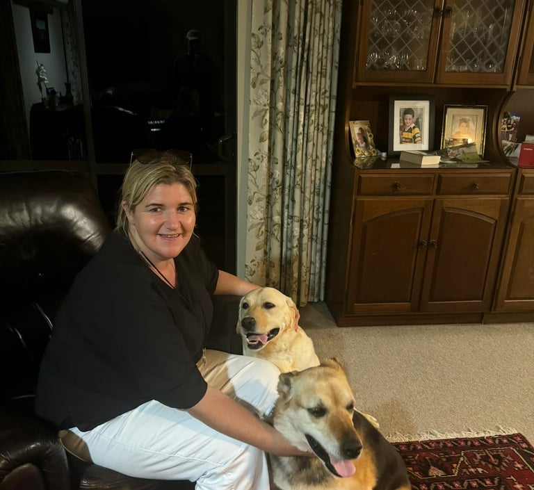 a woman sitting on a couch with two dogs