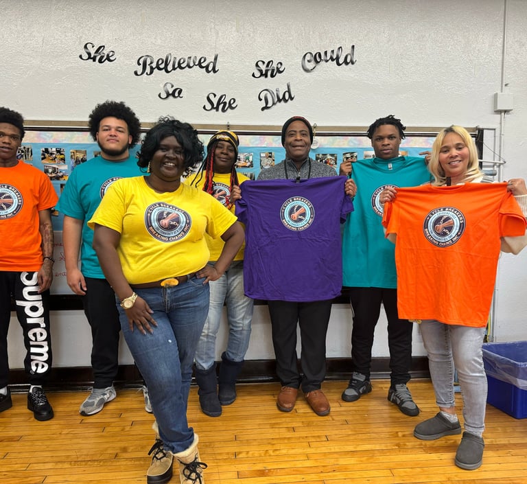 A group of diverse community members proudly holding up Cycle Breakers Breaking Chains T-shirts.