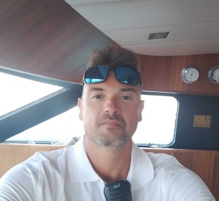 a man in a white shirt and sunglasses, yacht skipper