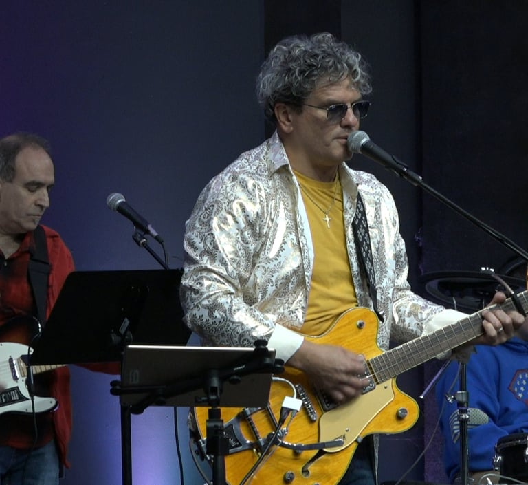 Sonny Cashbaugh playing guitar and singing into a microphone
