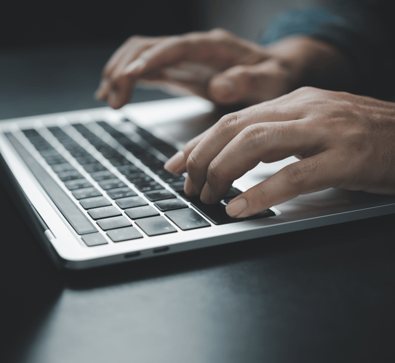 Close-up of hands typing on a laptop keyboard, representing research and decision-making in selecting the best IT solutions f