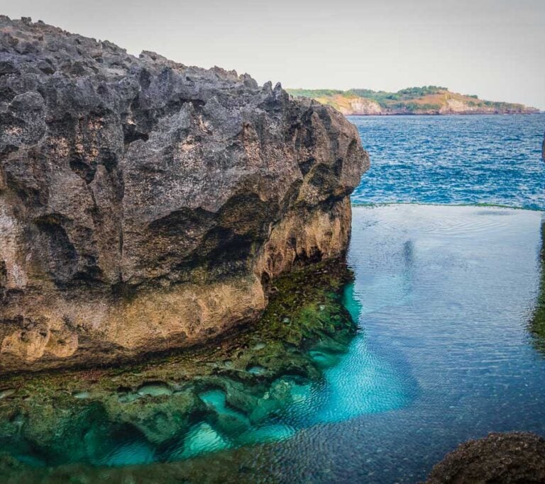 Angel's Billabong in Nusa Penida, Bali, featuring a natural rock infinity pool with clear turquoise water.