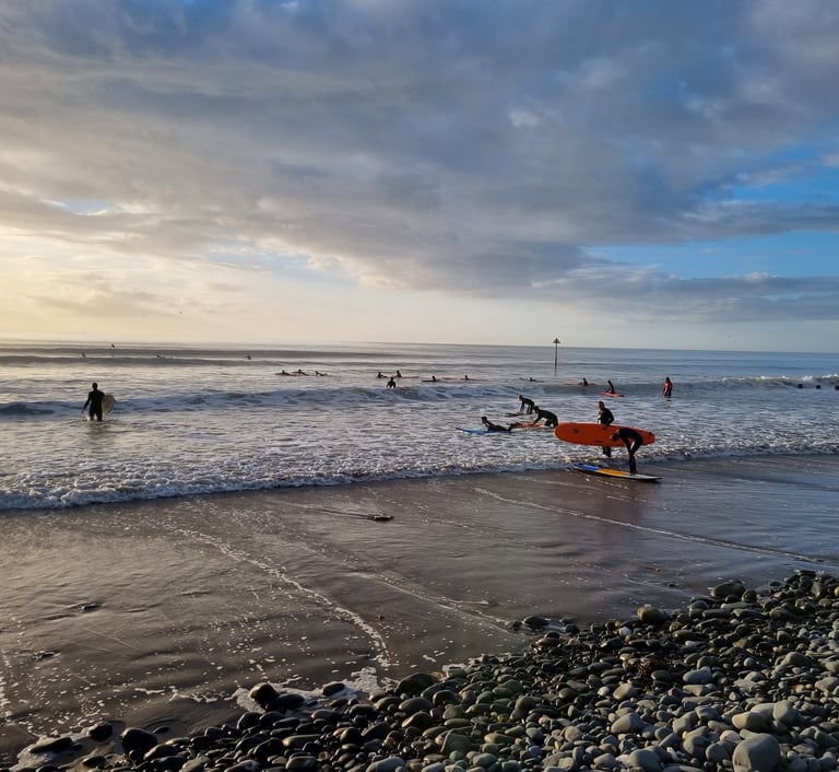 An evening surf lesson at Ynyslas, with big clean waves and lots of surfers enjoyig the sea.