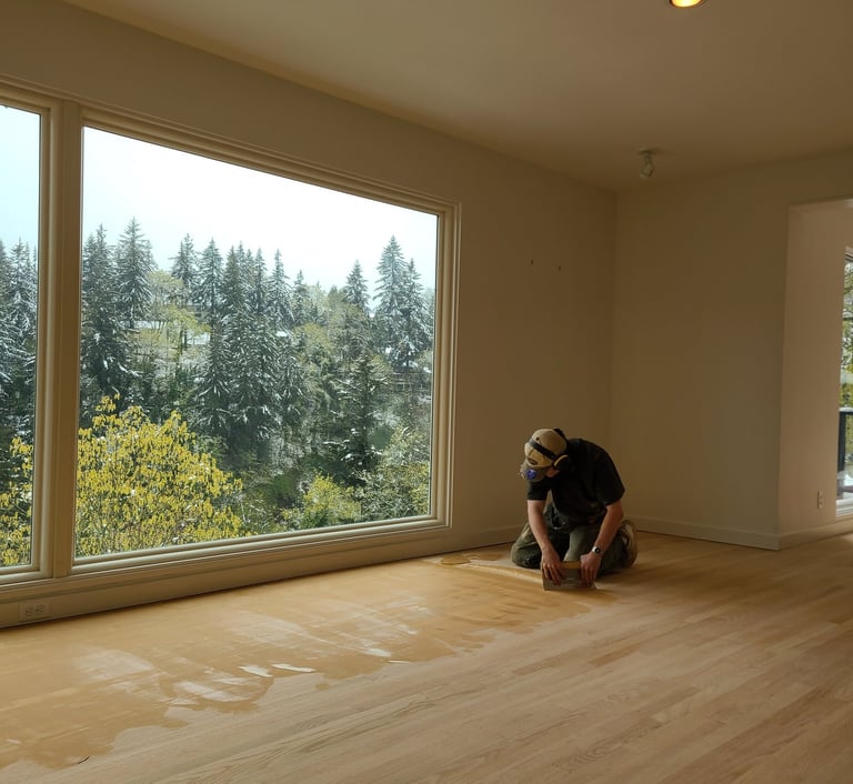 a craftsman trowel filling a hardwood floor with wood grain filler