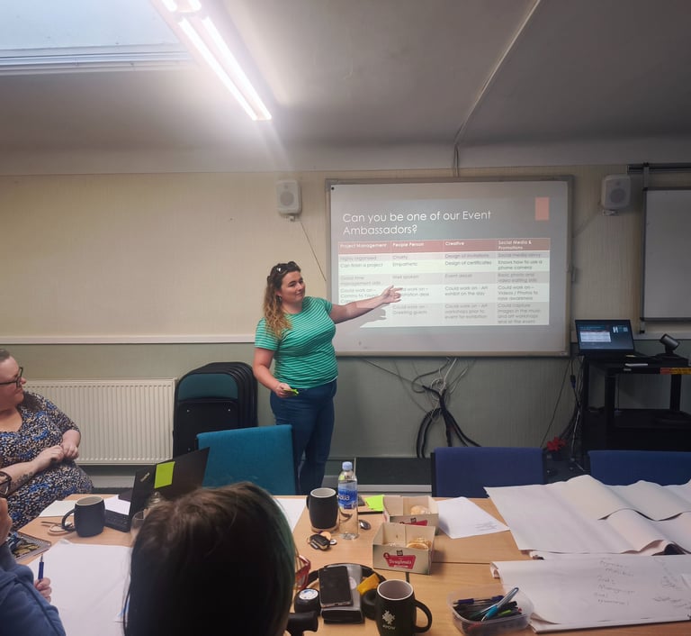 a woman in a green shirt is standing in front of a presentation