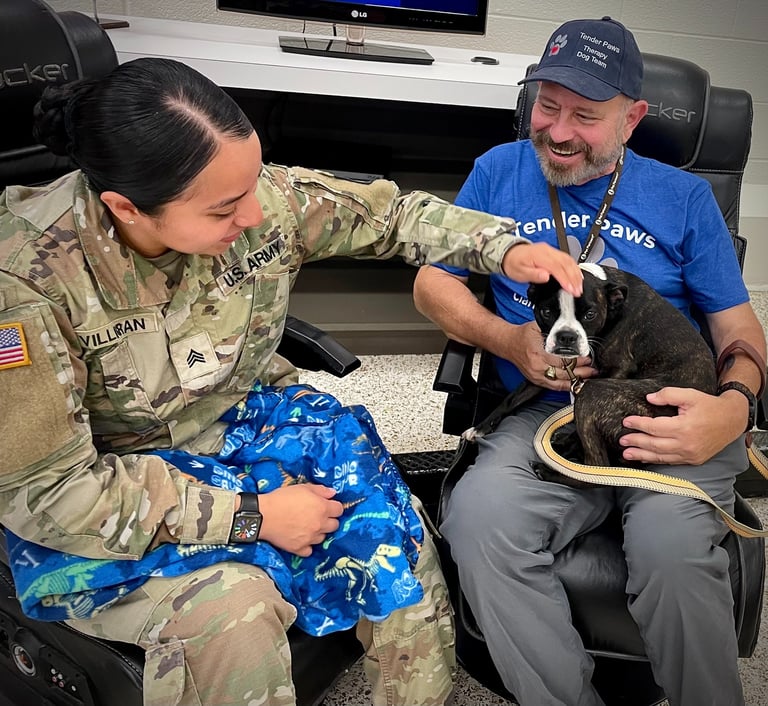 A female Soldier interacts with Tender Paws Therapy Dog Piper and her Handler, FDavid.