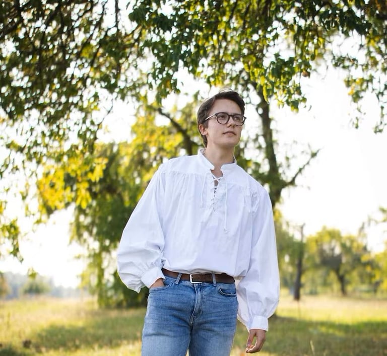 Man in blue jeans wearing an eighteenth century style mens shirt.