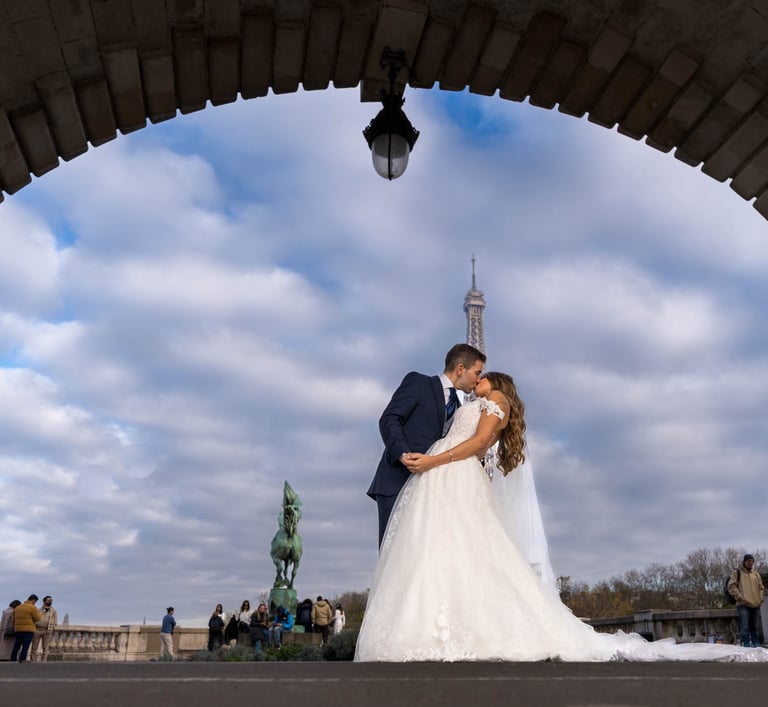 "Pareja heterosexual casada besándose bajo la Torre Eiffel en París, celebrando su amor y unión."