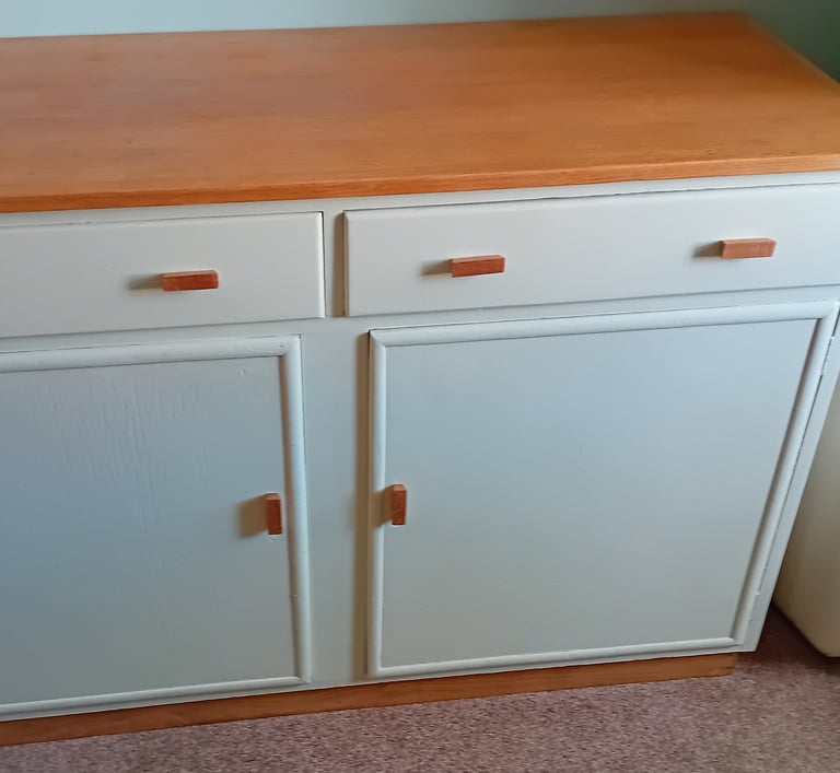 Finished cupboard painted a very light green with natural oak top and handles.