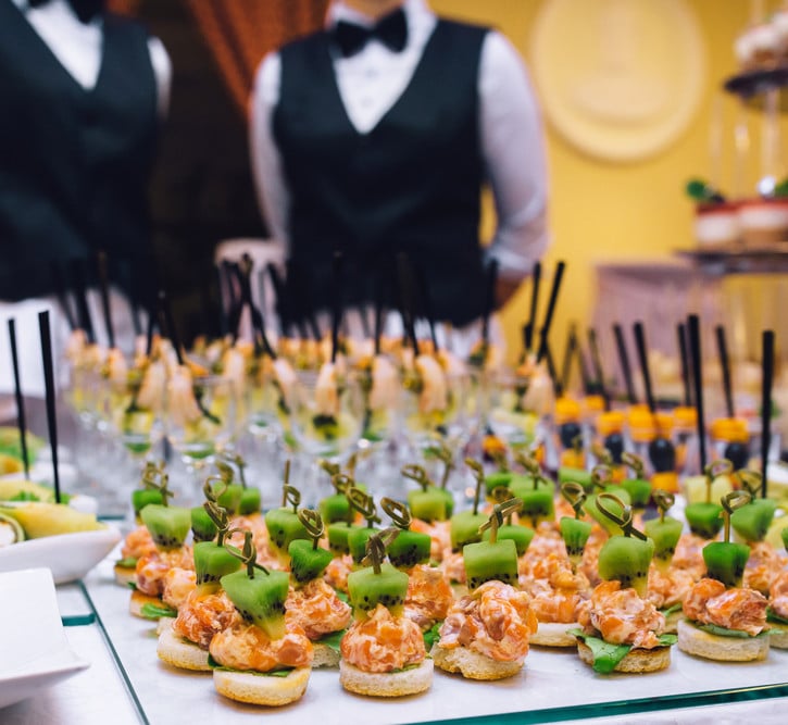 Mesa de sushi com garçons prontos para servir