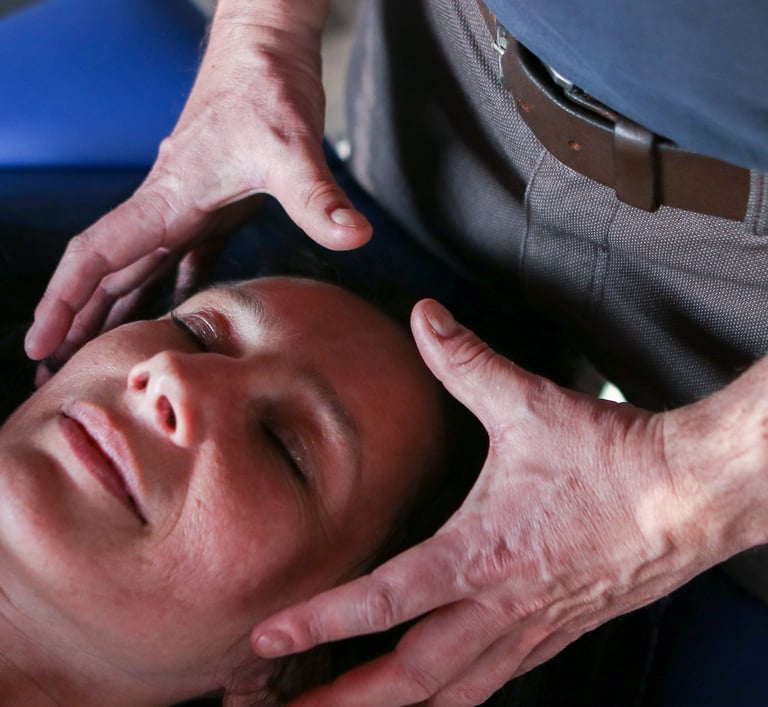 Les mains du praticien entourent la tête de la patiente