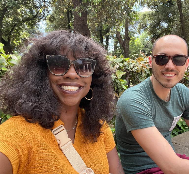 a man and woman sitting on a bench in a park